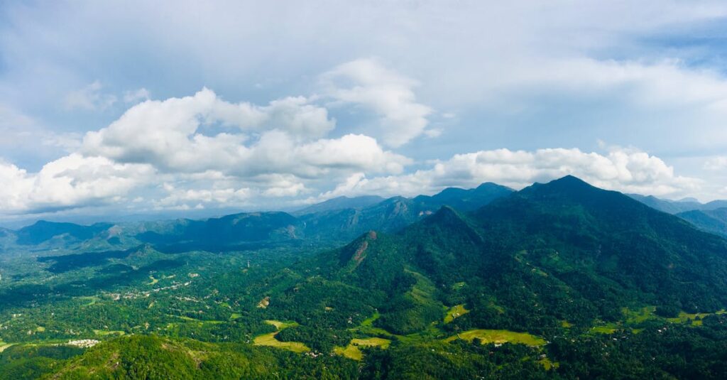 An expansive view of verdant mountains and valleys under a bright sky in Kegalle, Sri Lanka.