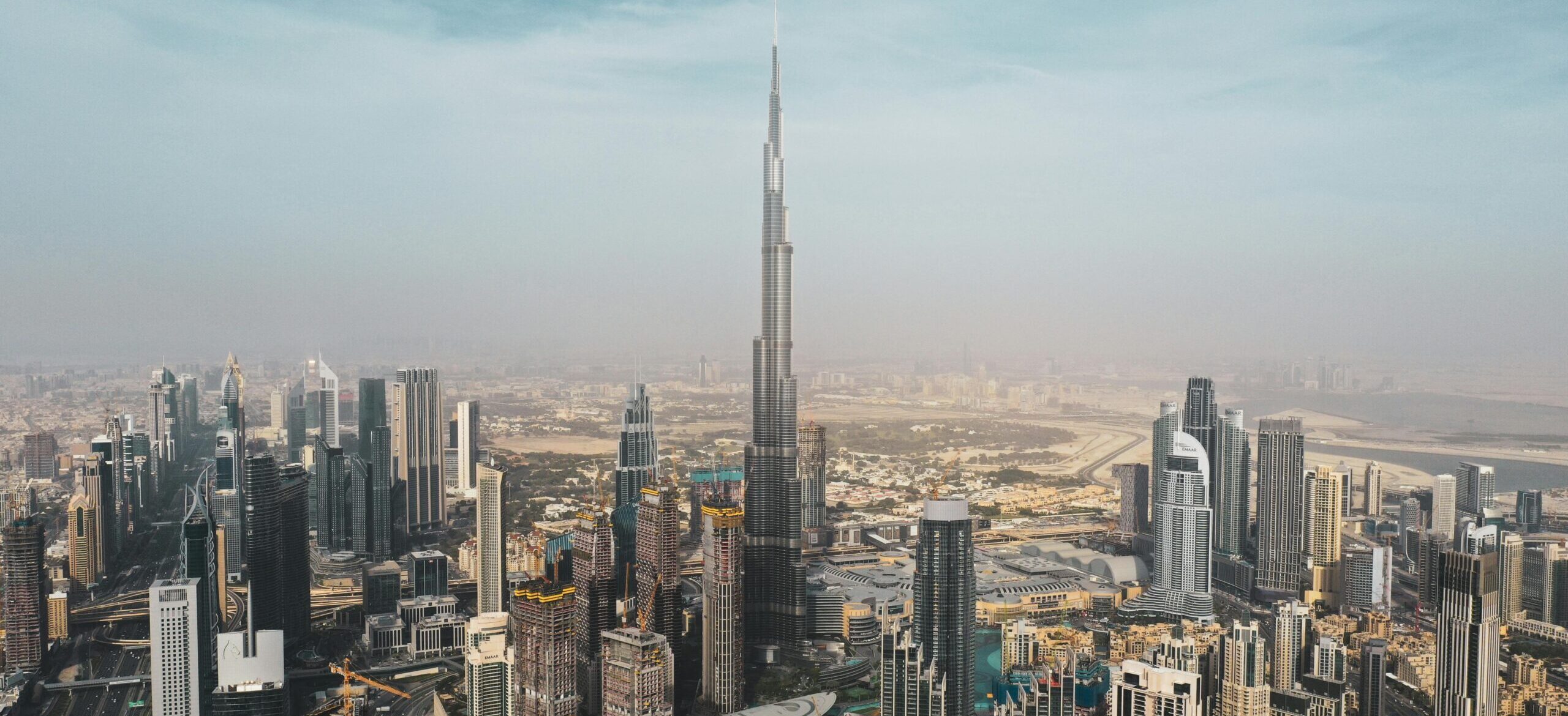 A breathtaking aerial view of Dubai's skyline featuring Burj Khalifa amidst modern skyscrapers under a clear sky.