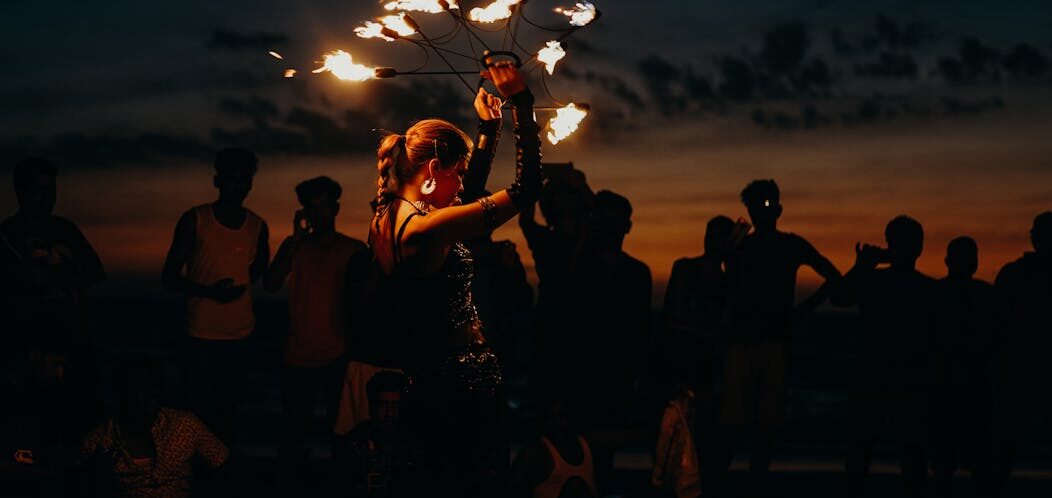 A mesmerizing fire dancer entertains a crowd at sunset on Arambol Beach, India.