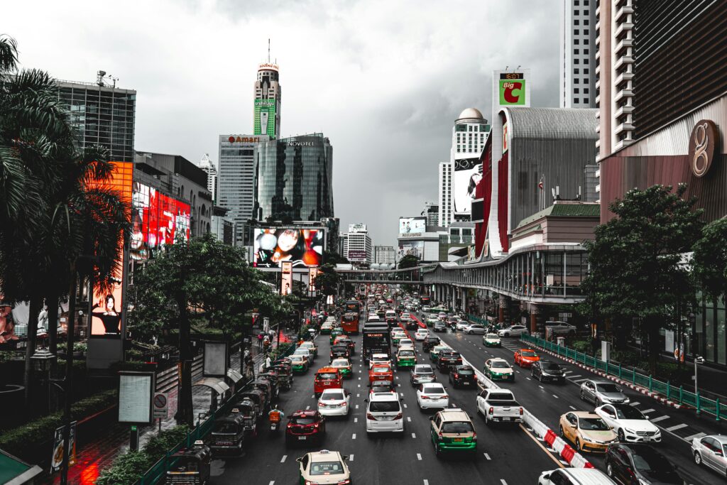 Dynamic view of traffic and skyscrapers in Bangkok, showcasing urban life.