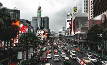 Dynamic view of traffic and skyscrapers in Bangkok, showcasing urban life.