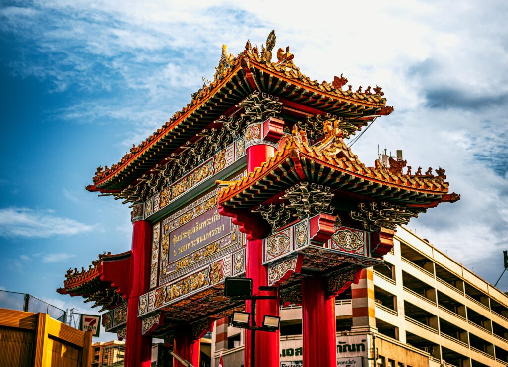 Vibrant Chinatown gate under clear sky in Bangkok, showcasing traditional architecture.