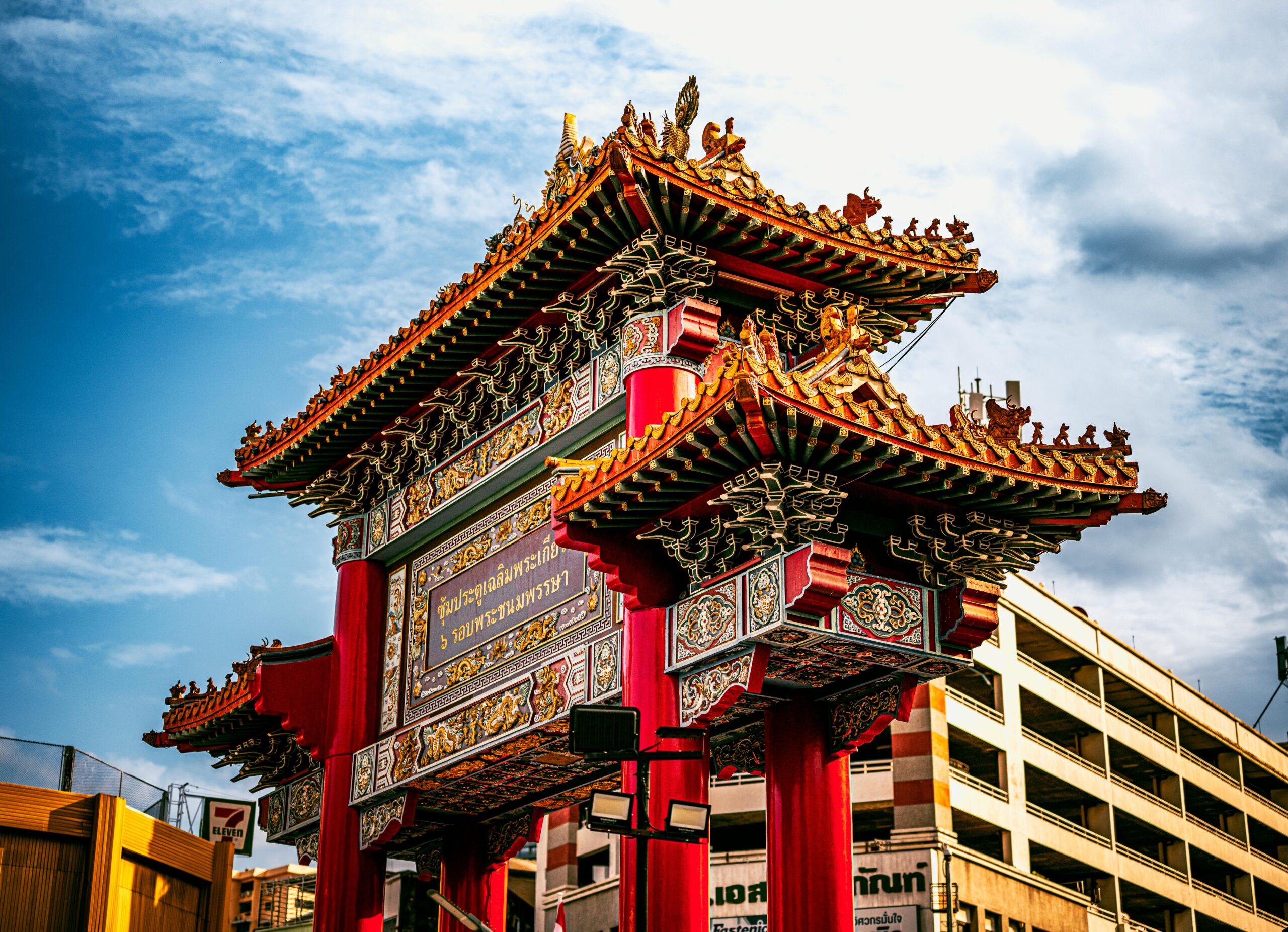 Vibrant Chinatown gate under clear sky in Bangkok, showcasing traditional architecture.